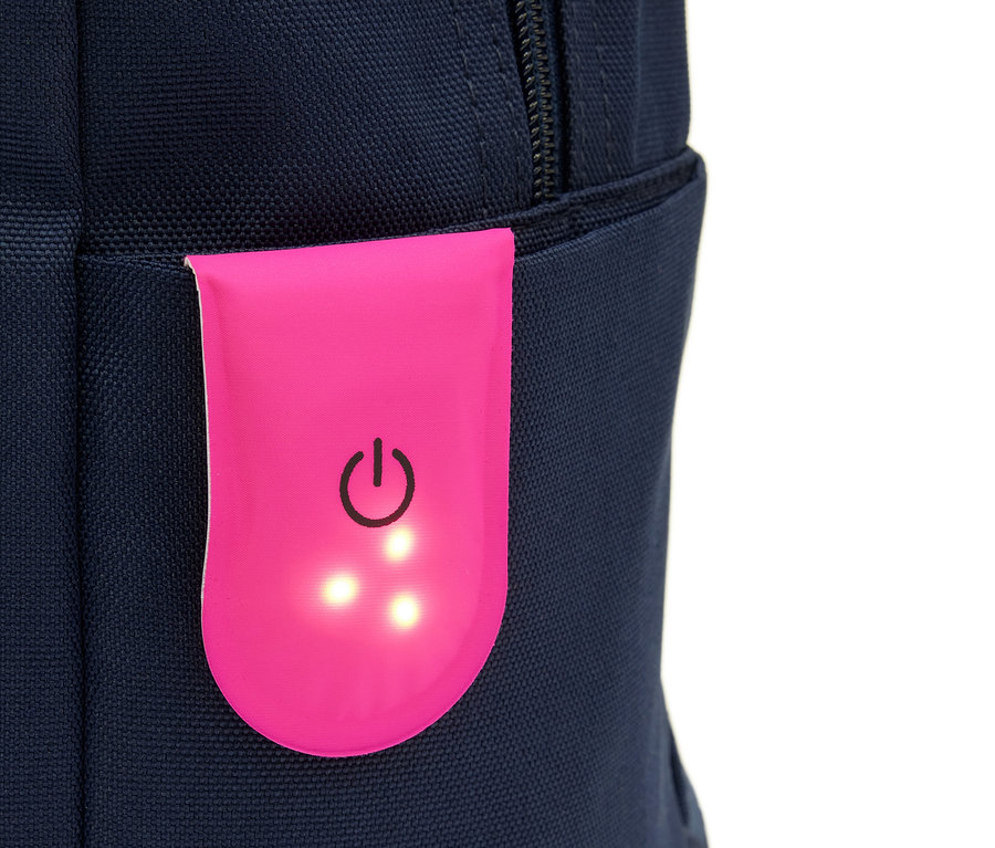 Detailaufnahme eines blauen Rucksacks mit einem pinkfarbenen Licht mit Netzschalter.