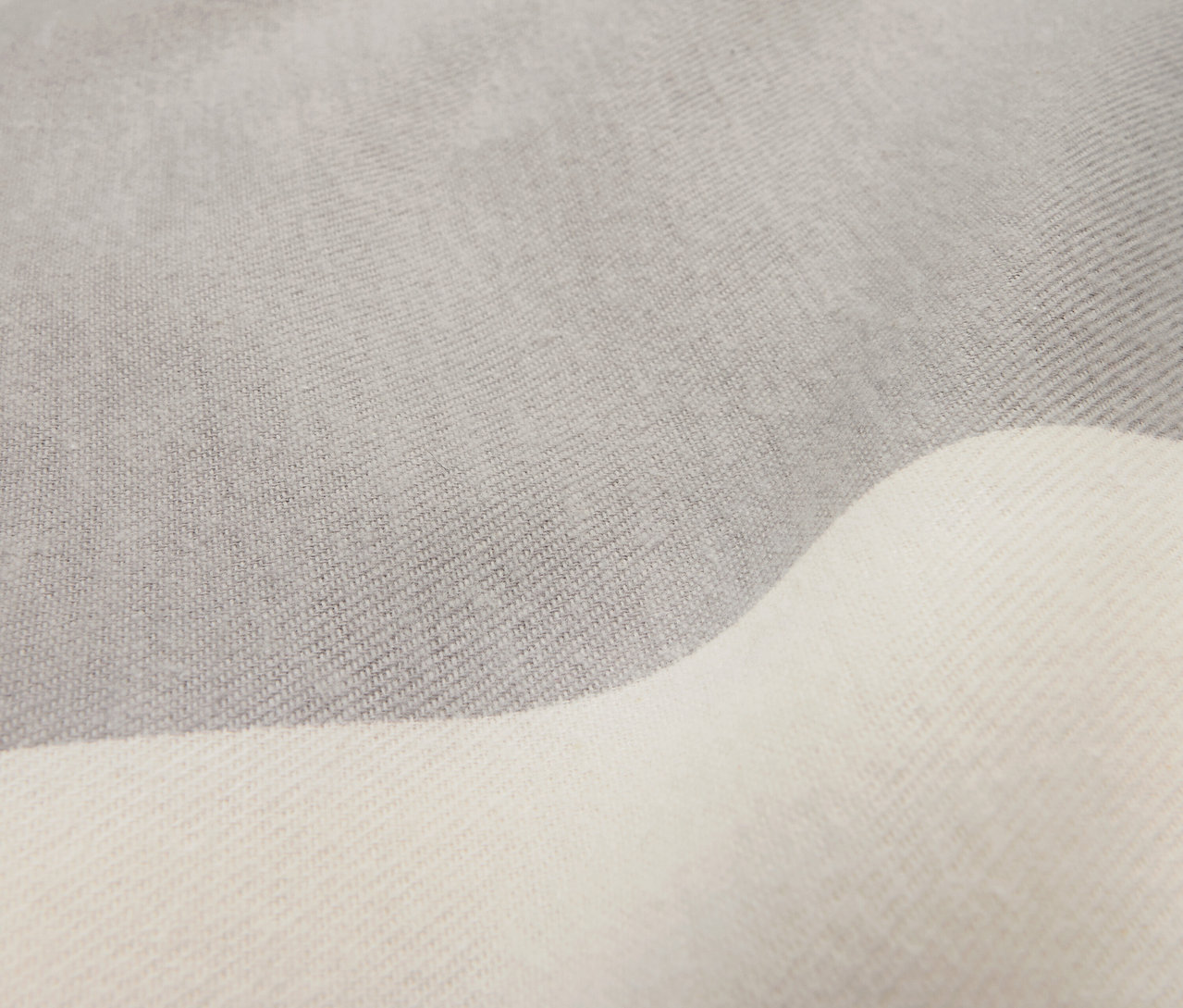 Detailaufnahme von Flanell-Bettwäsche in Normalgröße in Grau und Weiß.