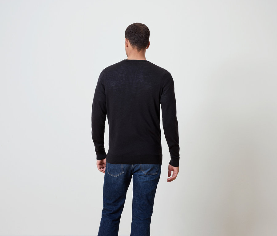 Mann von hinten, trägt einen dunklen Pullover und Jeans.