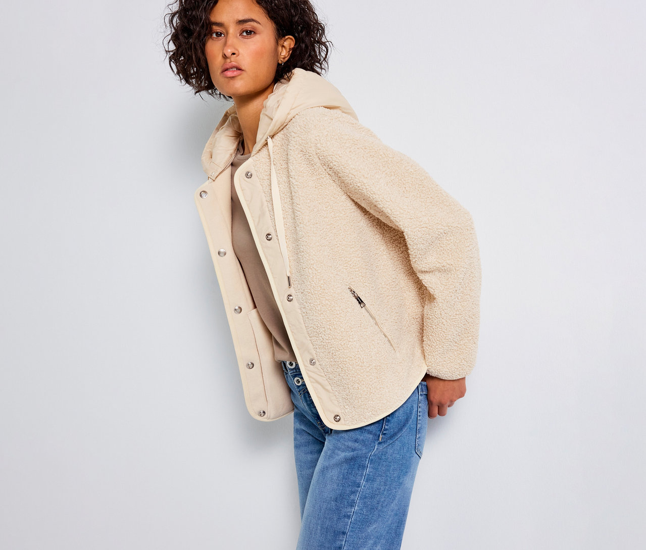 Frau trägt eine Street One Teddyjacke mit abnehmbarer Kapuze und Jeans.