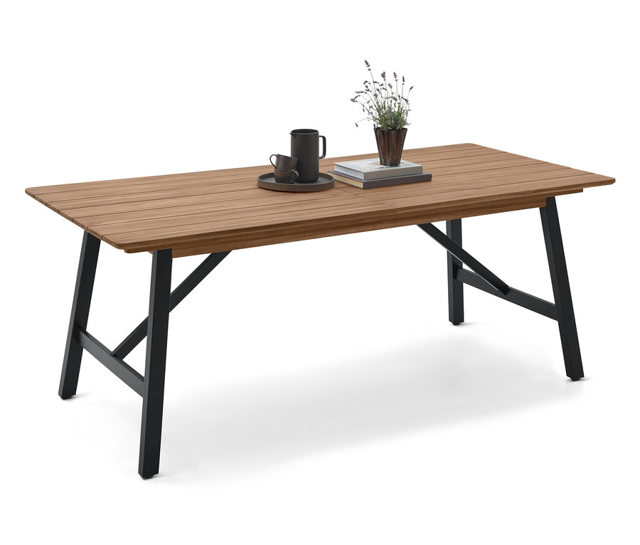 Auf einem Holztisch mit schwarzen Beinen stehen eine Tasse, eine Untertasse, ein Buch und eine Pflanze.