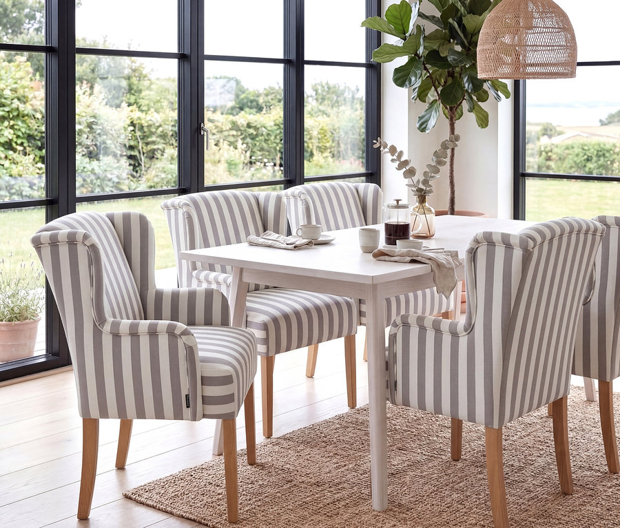 Esszimmer mit Esstisch und vier »Hendrick« Polsterstühlen mit Armlehne in Grau-Weiß gestreiftem Stoffbezug.