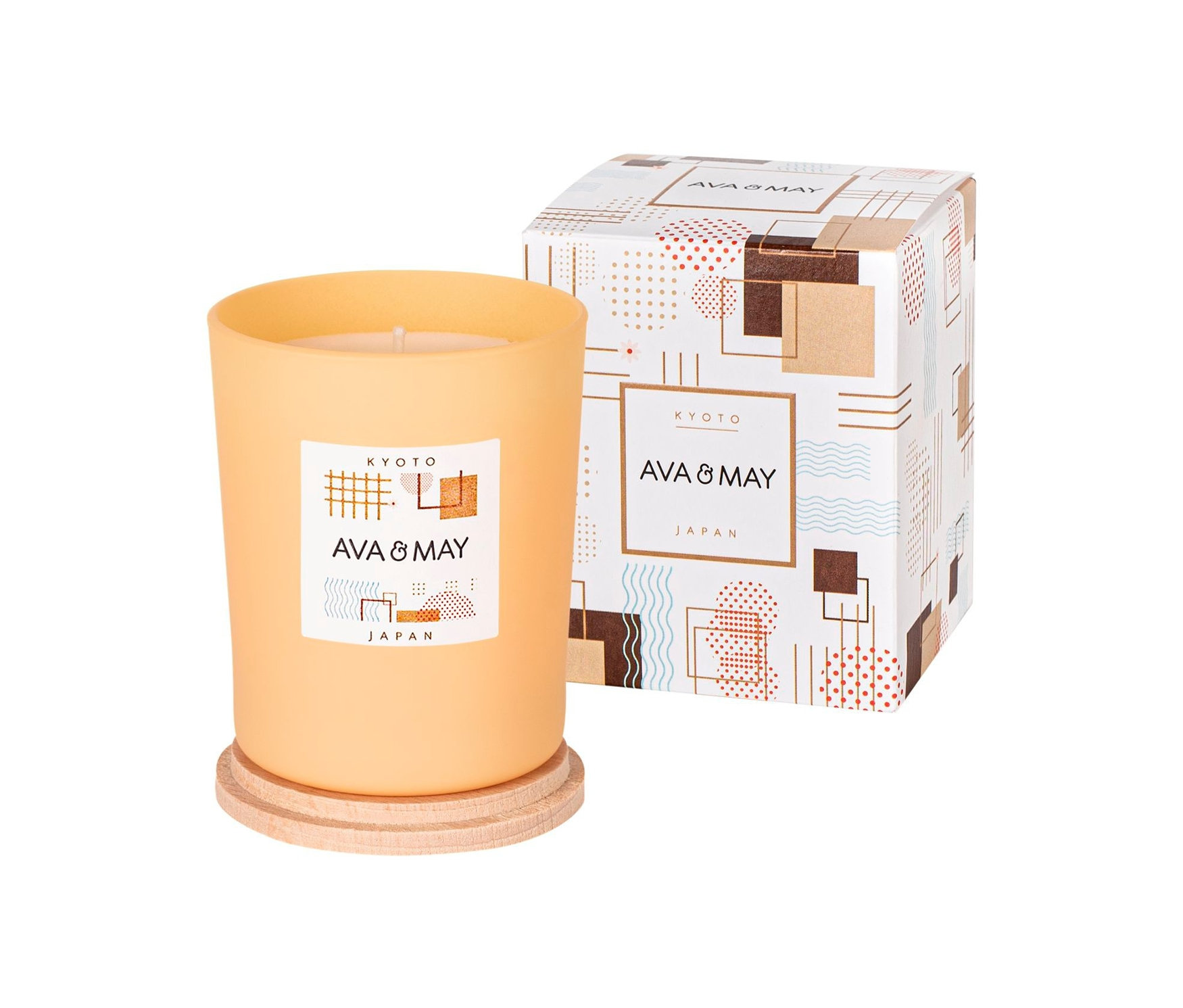 Eine orangefarbene Duftkerze »Kyoto« von Ava&May steht neben dem Karton.