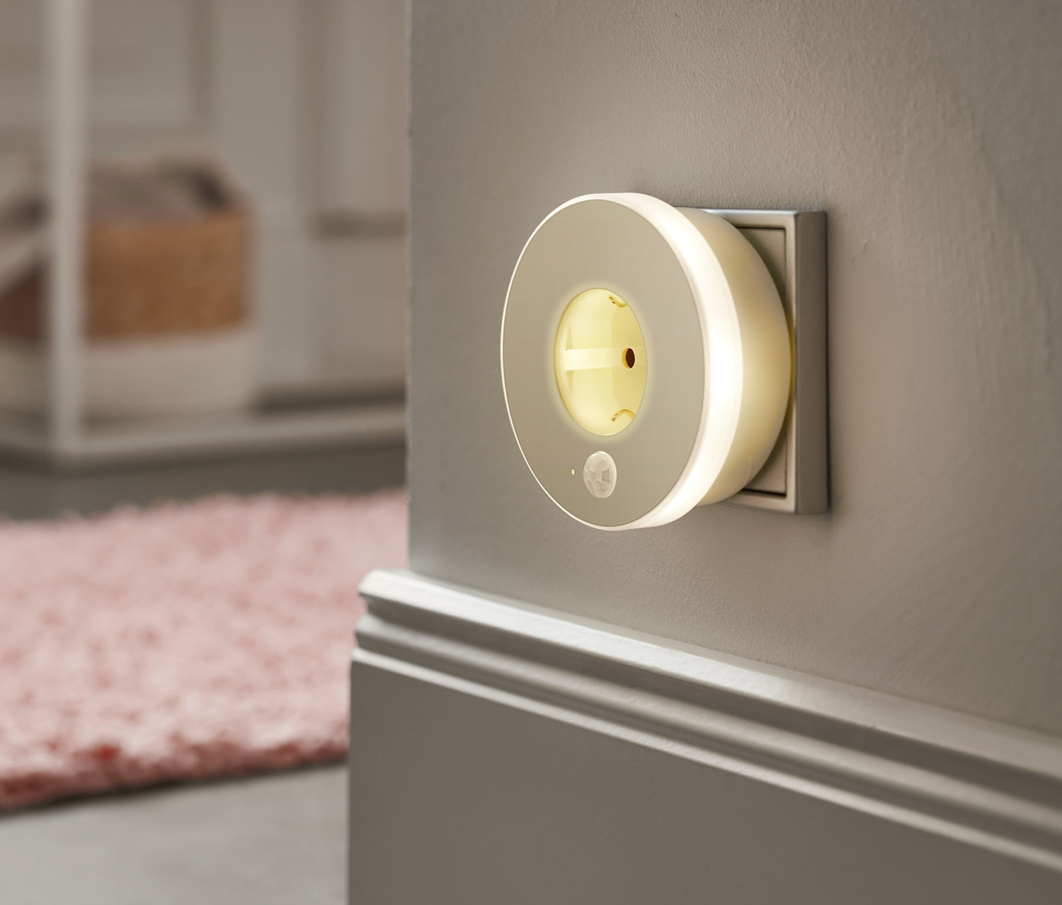 Ein LED-Nachtlicht mit Steckdose ist in eine Steckdose gesteckt.