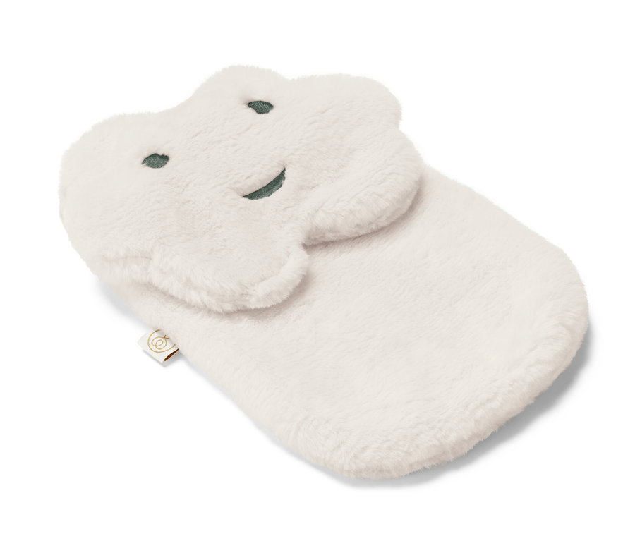 Eine weiße Wärmflasche »Wolke« in Wolkenform mit aufgenähten Augen und einem Lächeln liegt auf einem weißen Hintergrund.