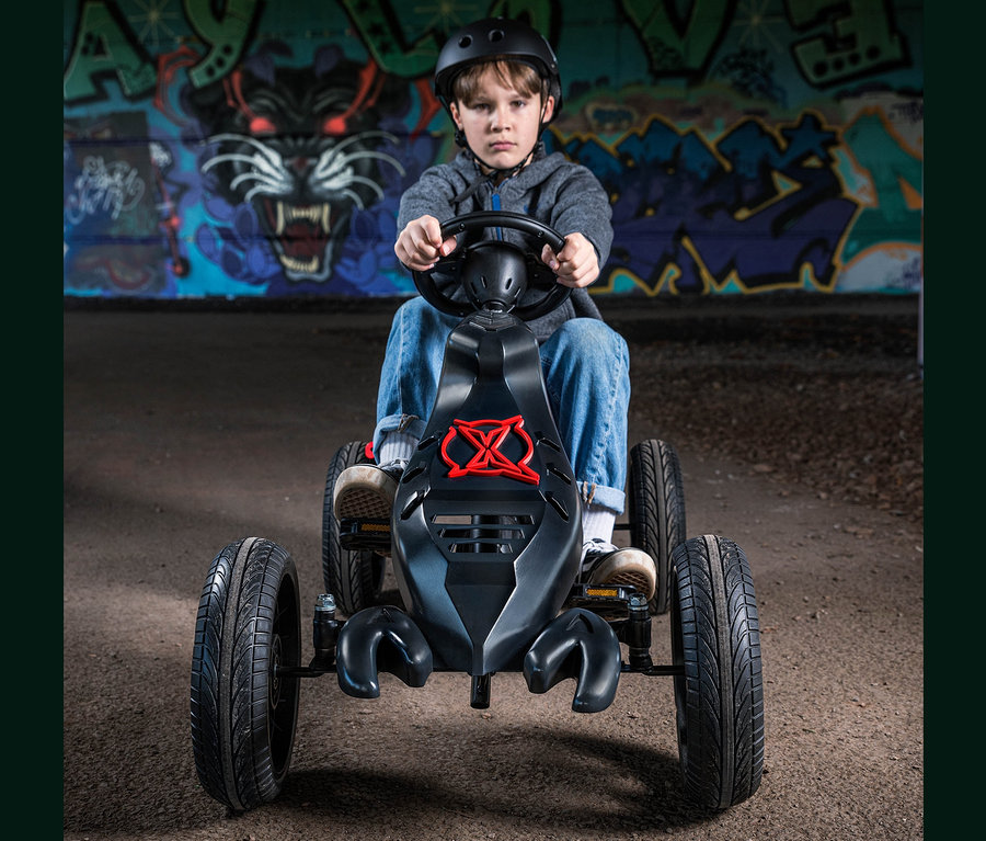 Ein Junge mit Helm fährt ein schwarzes Xootz Gokart »Venom«.
