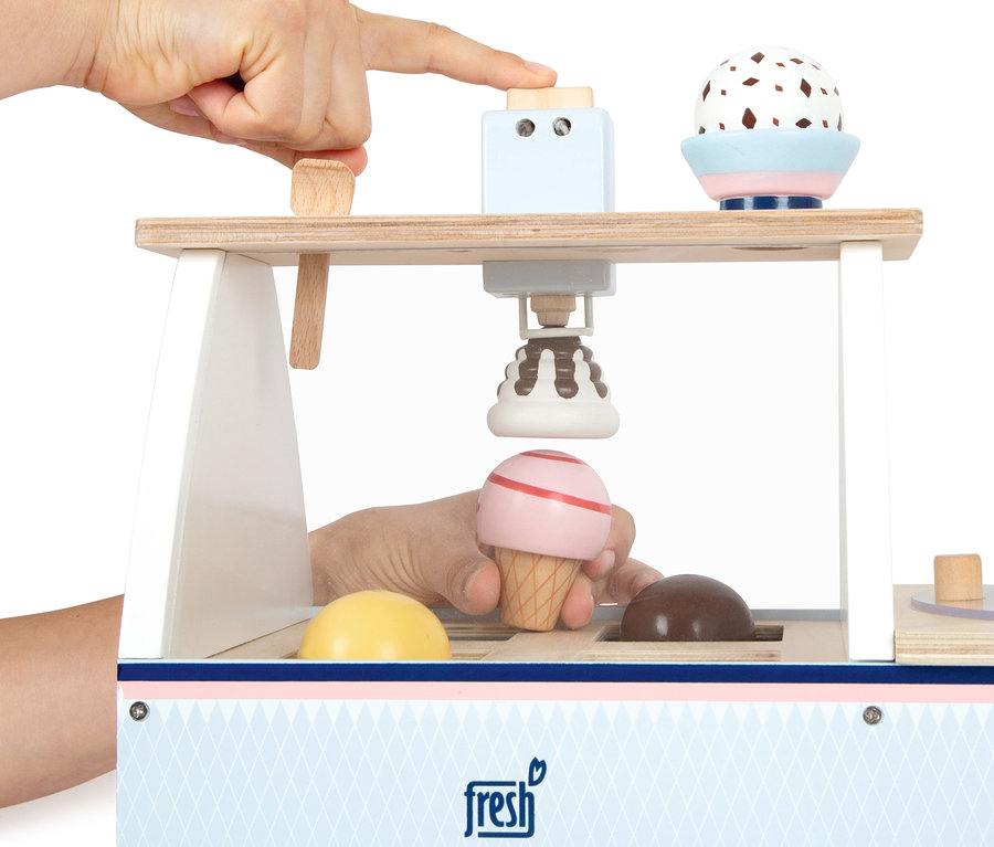 Eine Hand drückt einen Knopf an einem hölzernen small foot Eistheke »fresh«, unter dem sich ein rosa Eis in einer Waffel befindet.