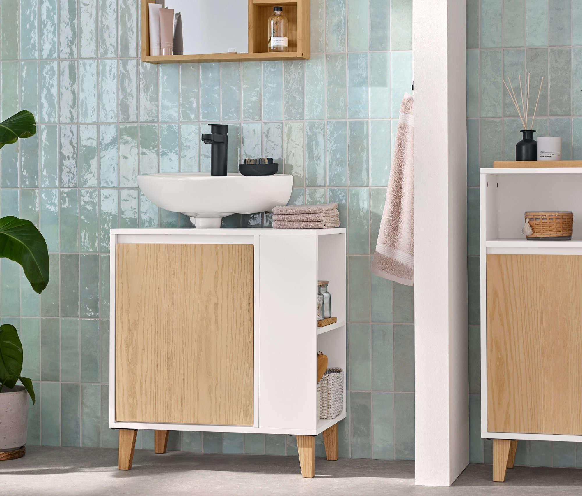 Badezimmer mit Spiegel mit Ablageflächen, Waschbeckenunterschrank mit Tür und seitlichem Fach und Sideboard mit 2 Türen und offenem Fach.