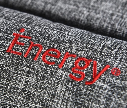 Detailansicht eines grauen Outdoor-Hundebetts mit roter "Energy"-Aufschrift.
