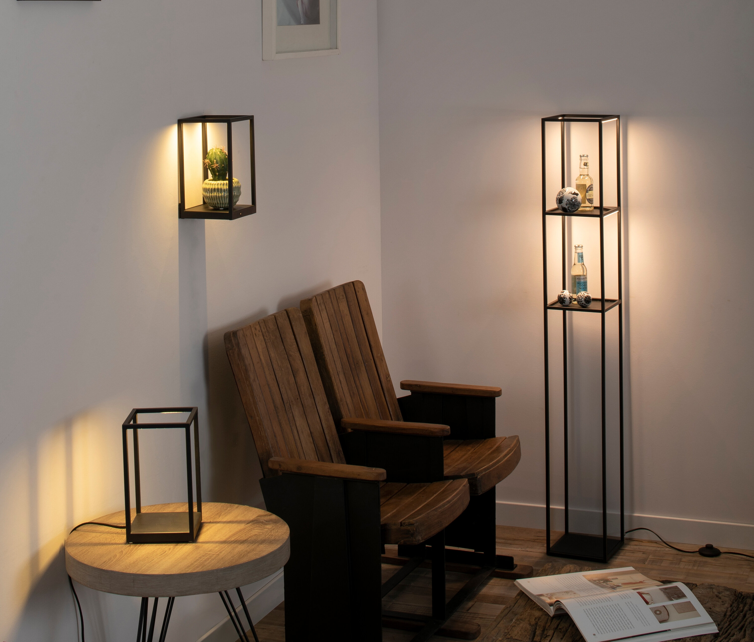 Innenraum mit einem Paar Holzstühle, einer Stehlampe mit Regalen, einer Wandlampe und einer Tischlampe.