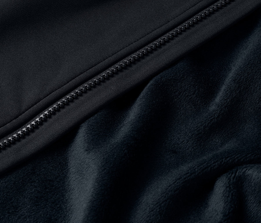Detail eines schwarzen Jackenreißverschlusses und flauschigem Fleecefutter.