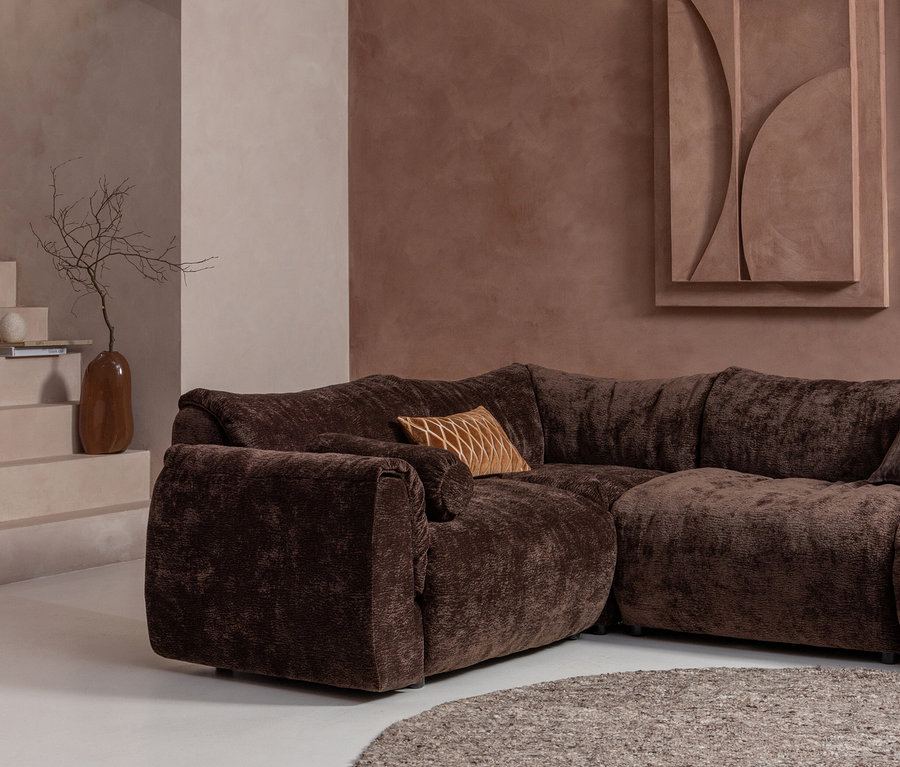 Nahaufnahme eines braunen Ecksofas mit Zierkissen auf einem braunen Woood Teppich »Efia«, Ø 200 cm.