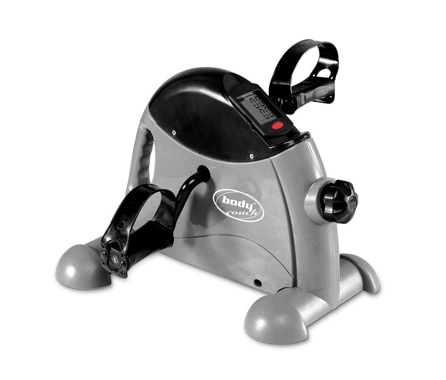 Detailansicht eines grauen Mini-Heimtrainers mit schwarzen Pedalen und Digitalanzeige.