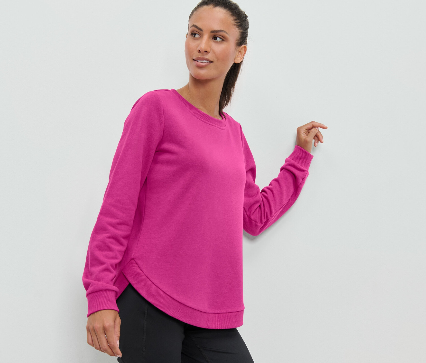 Frau trägt ein pinkes Sport-Sweatshirt.