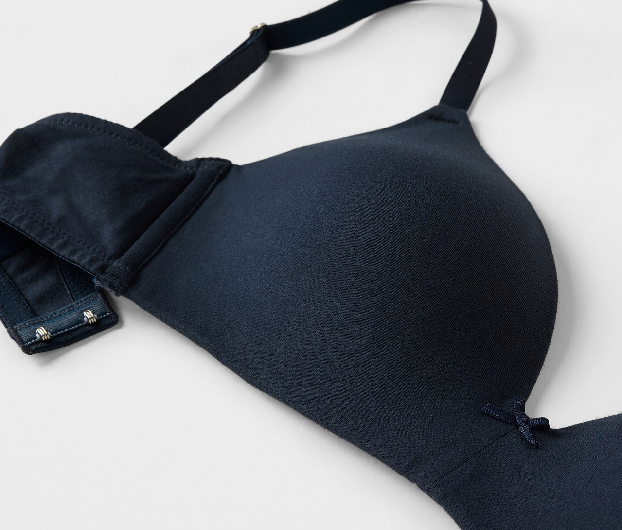 Detailansicht eines marineblauen BHs mit verstellbaren Trägern und Hakenverschluss.