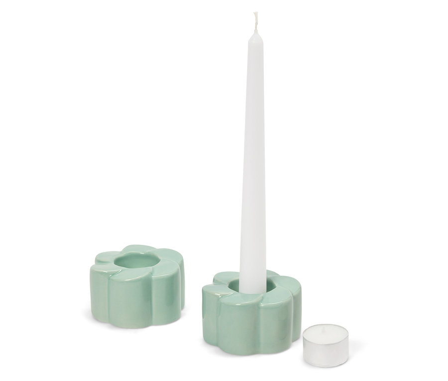 Zwei hellgrüne, blütenförmige Kerzenhalter, einer mit einer weißen Kerze, daneben ein Teelicht.