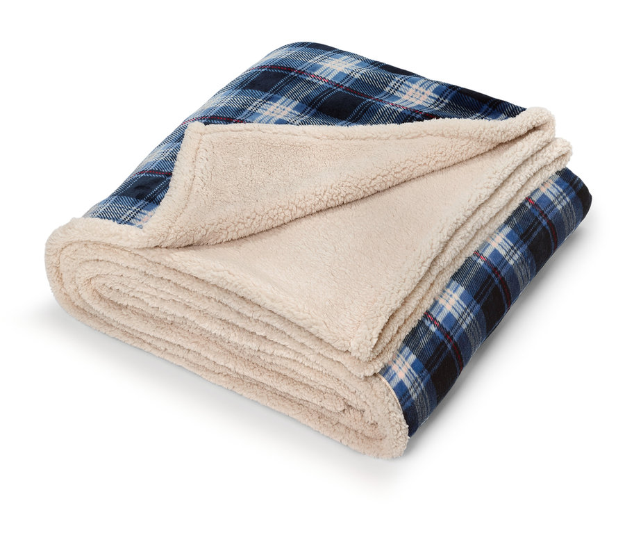 Zusammengefaltete Decke mit blauem Karomuster und cremefarbenem Sherpa-Futter.