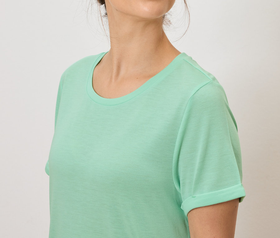 Frau trägt ein hellgrünes T-Shirt.