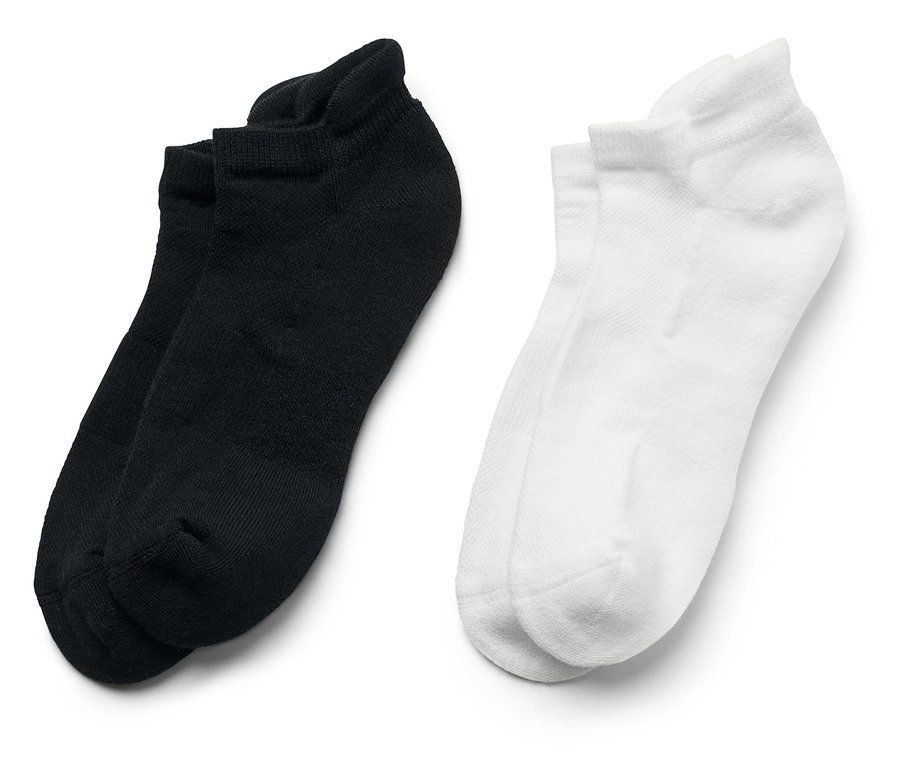 Zwei Paar kurze Socken, eines schwarz und eines weiß, liegen nebeneinander auf einem weißen Hintergrund.