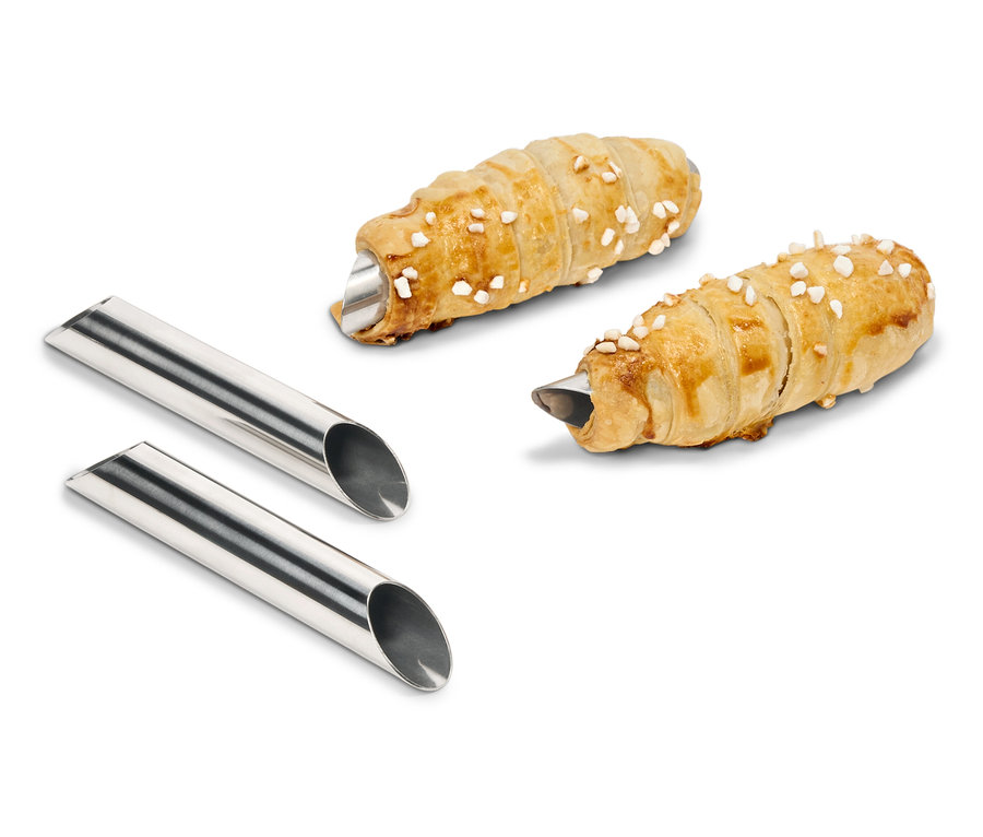 Zwei mit Creme gefüllte Teigrollen liegen neben zwei Metallformen.