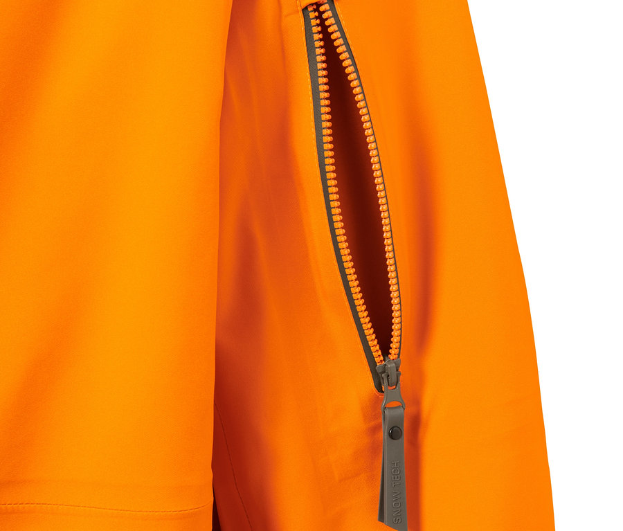 Detailaufnahme einer orangen Hardshell-Skijacke mit offenem Reißverschluss an der Tasche.