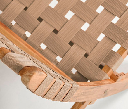 Detailaufnahme eines zusammenklappbaren Loungesessels mit braunem, gewebtem Sitz und Holzrahmen.