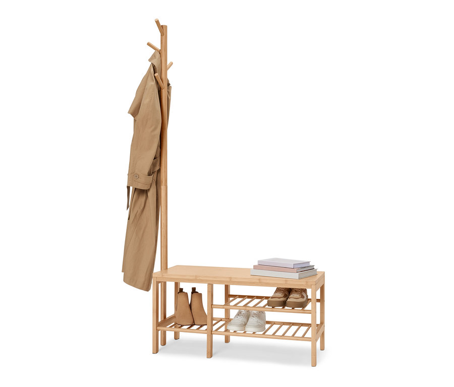 Eine Sitzbank mit Garderobenständer aus Bambus mit Schuhen und Büchern.