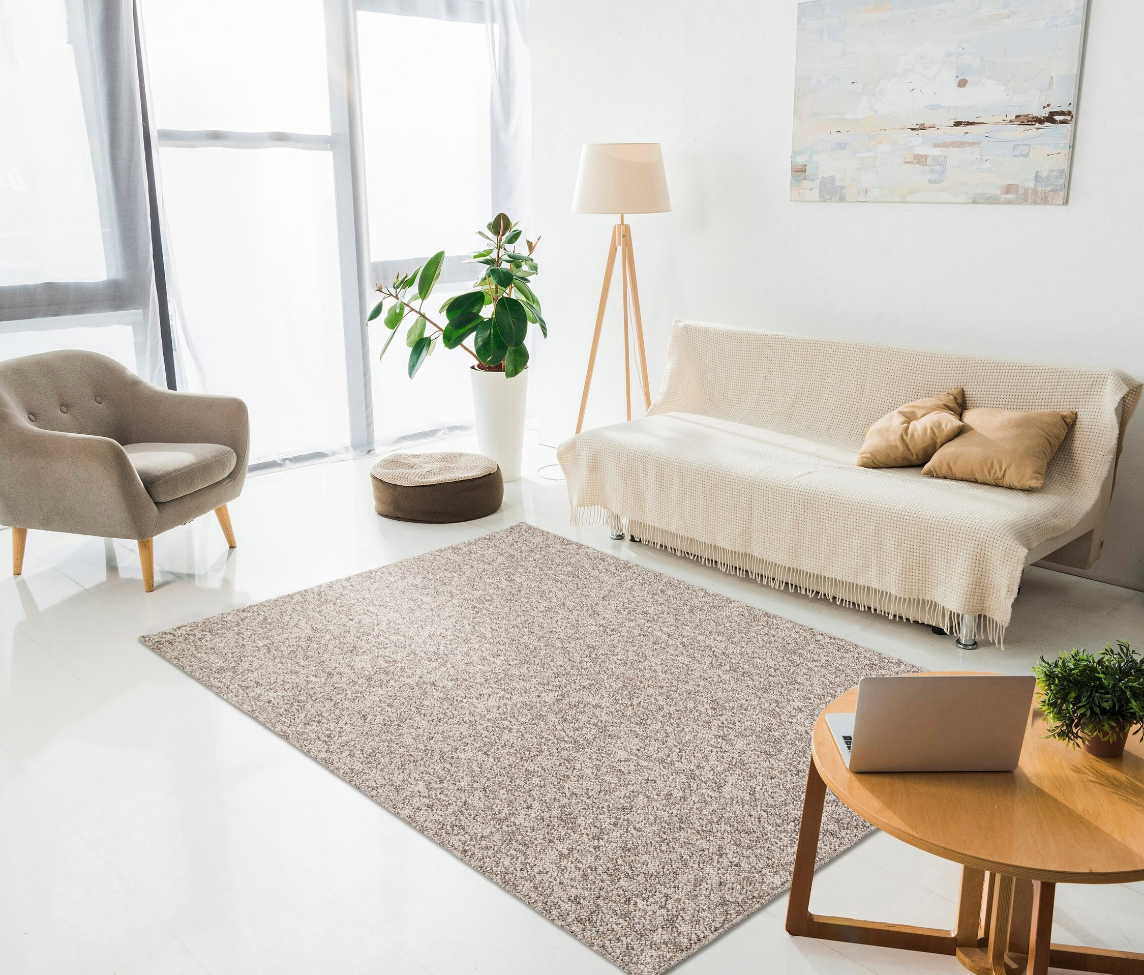 Wohnzimmer mit beigem Sessel, Sofa und Couchtisch. Auf dem Boden liegt ein beiger Teppich.