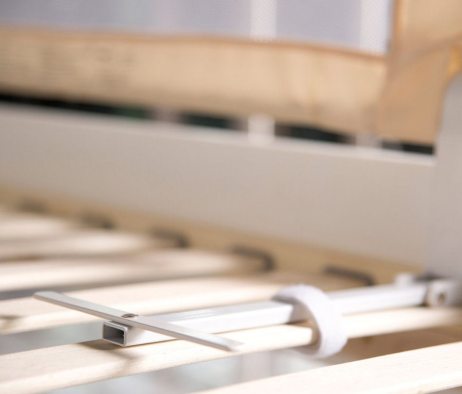 Detailansicht eines beigen roba Bettschutzgitters »Klipp-Klapp«, das an einem Bettrahmen befestigt ist.