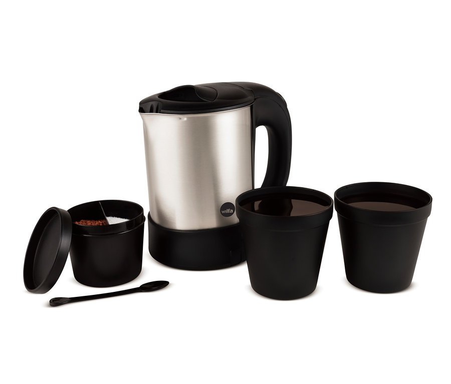 Ein silberner Wilfa Wasserkocher TRAVEL, »TK-1000« steht neben zwei schwarzen Tassen und einem offenen Behälter mit Kaffee und Zucker.