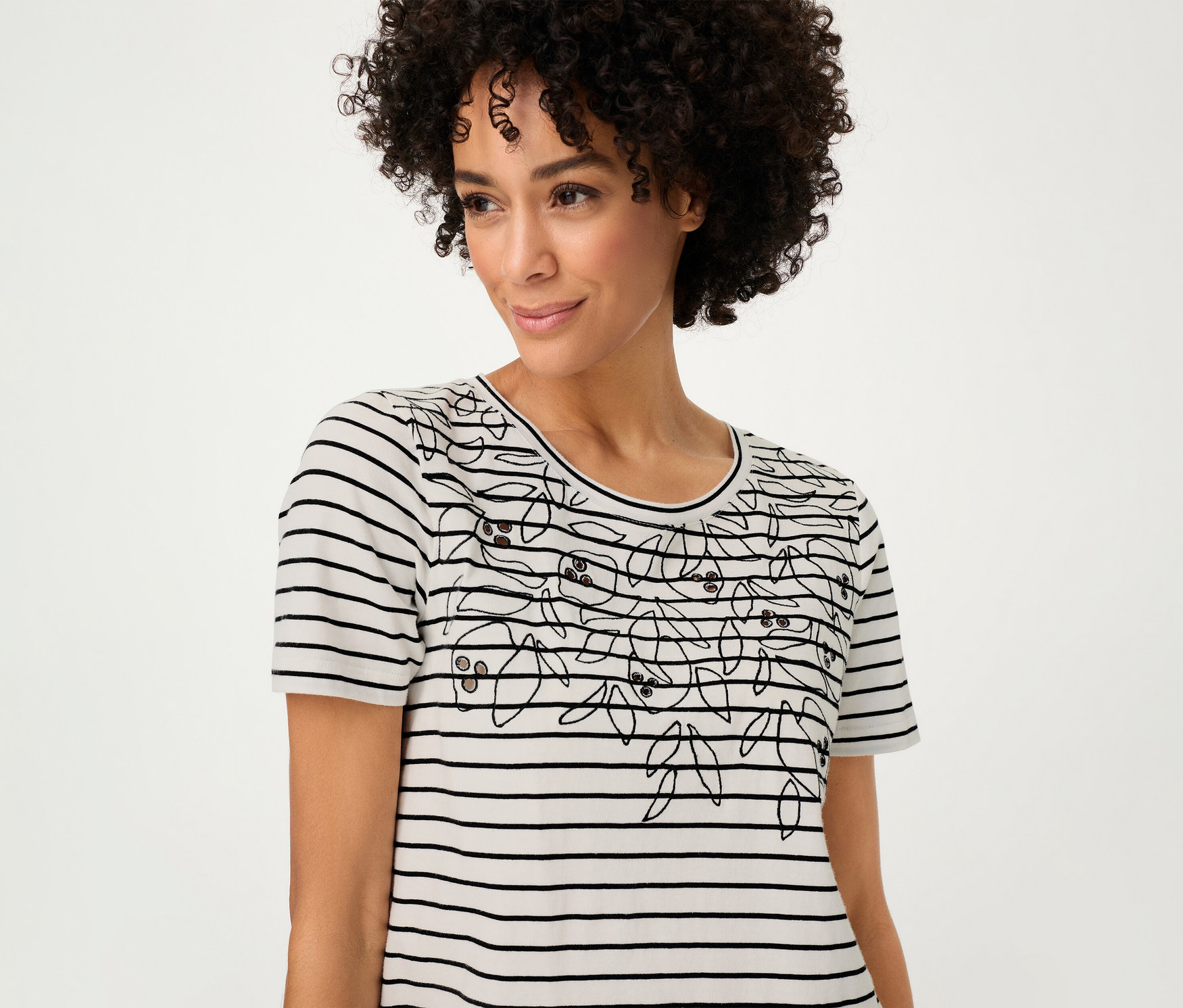 Frau trägt ein gestreiftes Olsen Shirt mit Blumenmuster.