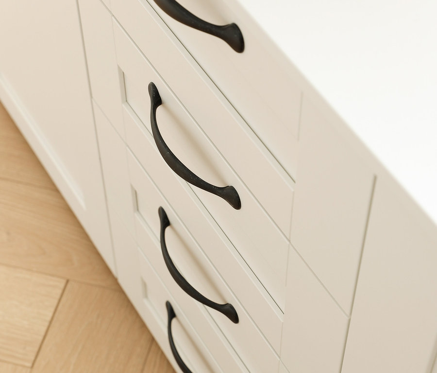 Detail einer weißen Kommode »Cottage« mit vier Schubladen und schwarzen Griffen.