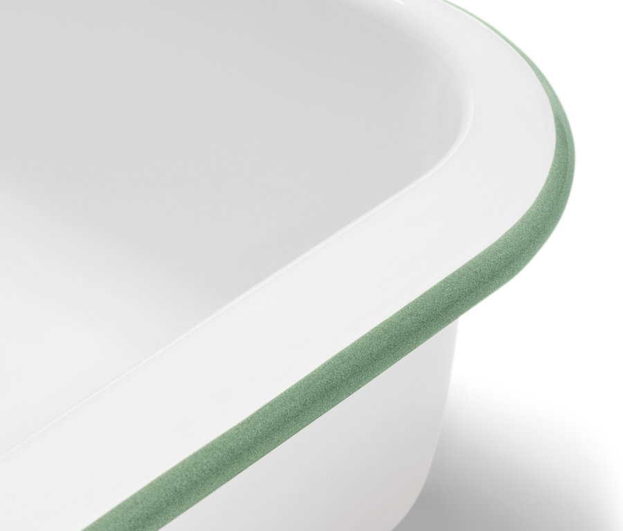 Detailansicht einer weißen Emaille-Auflaufform mit Deckel und grünem Rand.