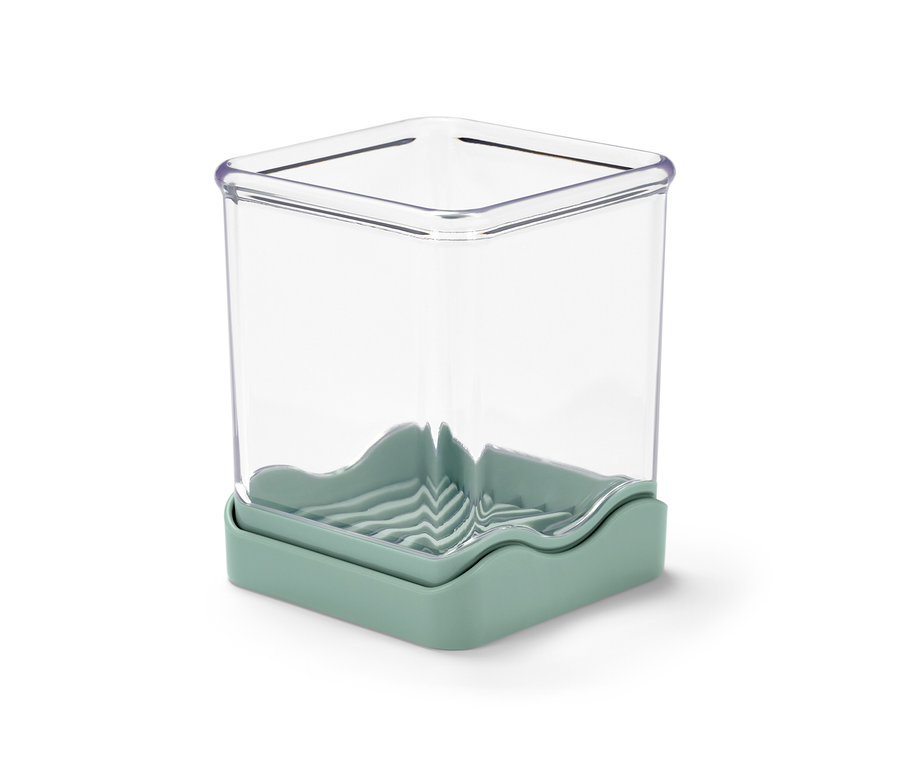 Ein durchsichtiger Obst- und Gemüseschneider mit hellgrünem Sockel.