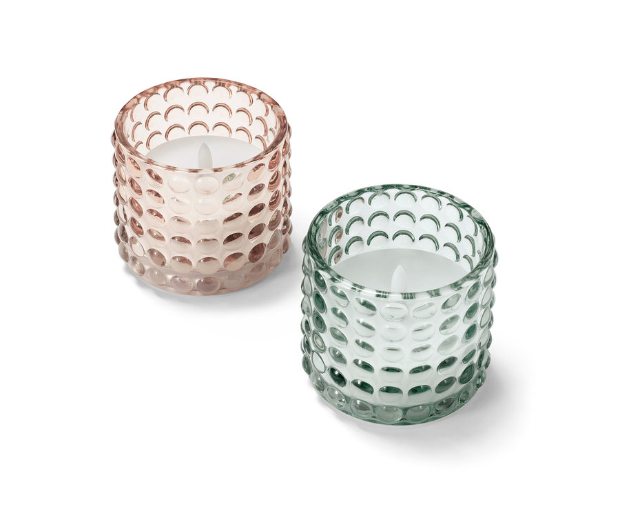 Zwei LED-Echtwachskerzen im Glas, eine rosa und eine grün.