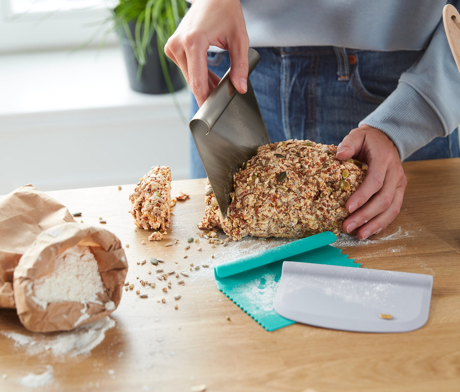 Person schneidet Brot mit einem Profi-Backhelfer-Set.