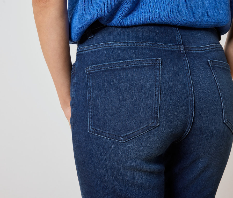 Nahaufnahme der Rückseite einer Frau, die eine dunkelblaue Jeans und ein blaues Oberteil trägt.