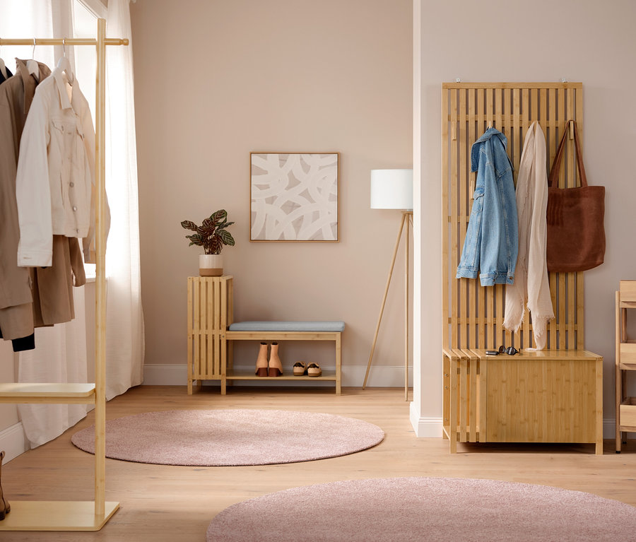 Einrichtungsszene mit einer Dreibein-Stehleuchte aus Holz und einem pinkfarbenen Teppich »Charme« mit ca. 160 cm Durchmesser.