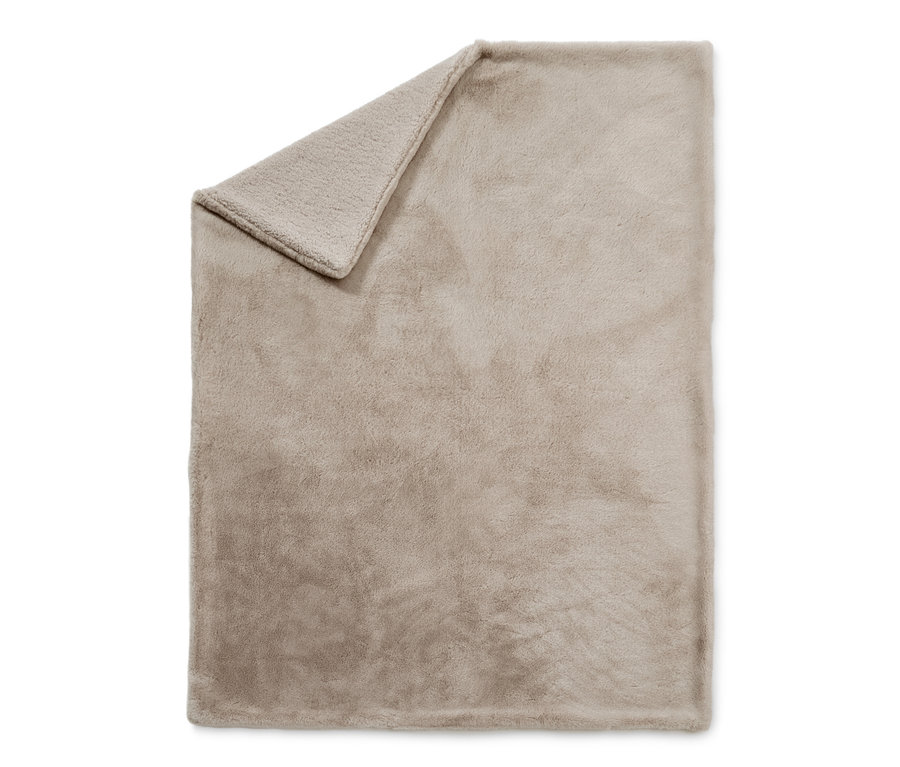 Beige Kuscheldecke aus Kunstfell, eine Ecke ist umgeschlagen.
