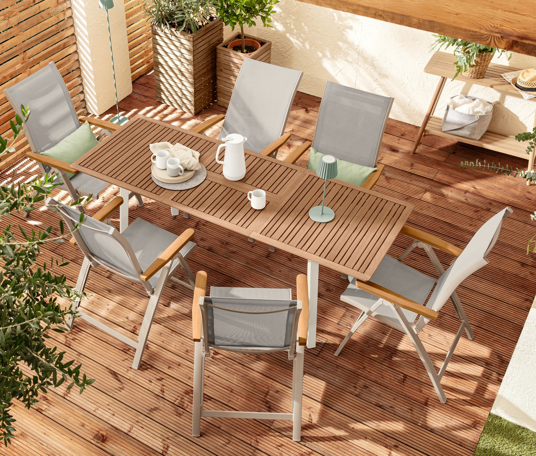 Eine Draufsicht einer Gartengarnitur mit sechs »Liska« Hochlehner, einem Ausziehtisch »Liska«, zwei LED-Akku-Tischleuchte, zwei Pflanzsäulen »Tinus« und einem Konsolentisch.