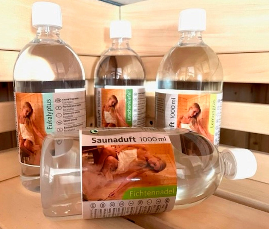 Vier Flaschen Karibu Sauna-Aufgusskonzentrat, je 1.000 ml, stehen auf einem Holzregal.