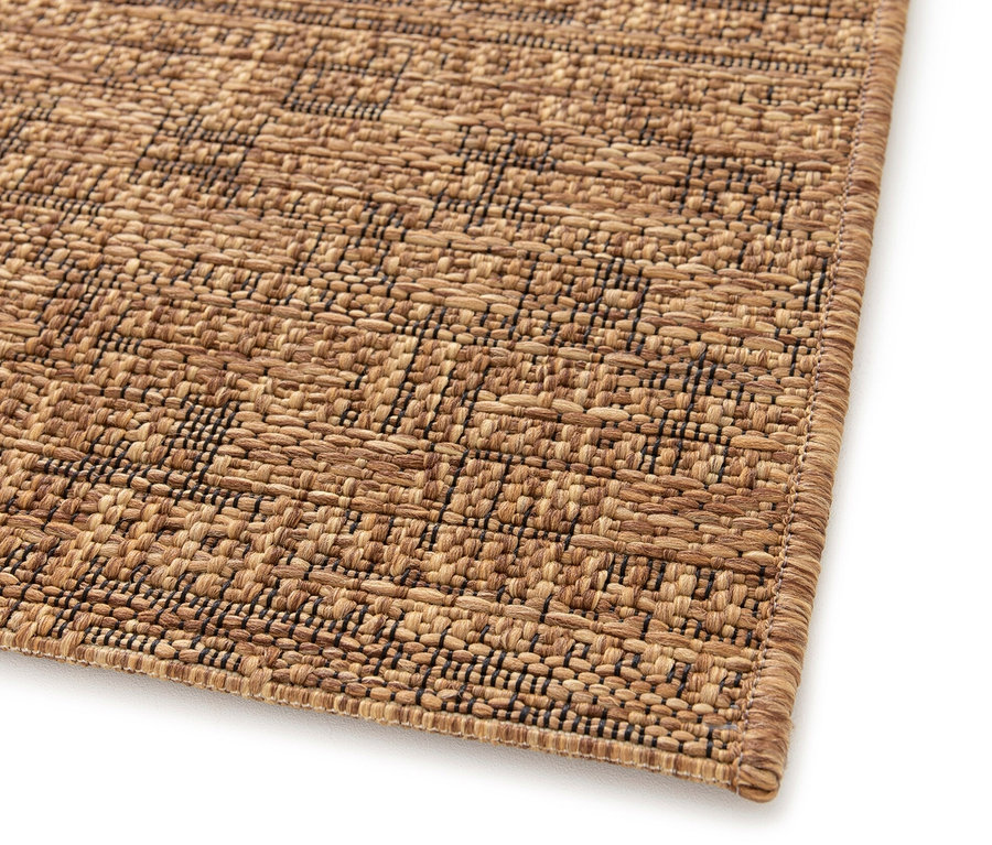 Detailansicht eines braunen Teppichs »Roy« mit einem geometrischen Muster.