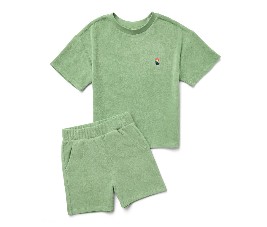 Ein grünes Kinder-Frottier-Set aus T-Shirt und Shorts liegt auf einem weißen Hintergrund.