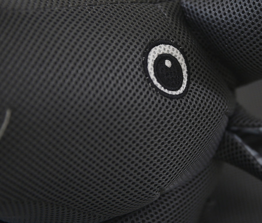 Nahaufnahme eines grauen Stofftier-Elefanten mit Netzstruktur und aufgenähtem Auge.