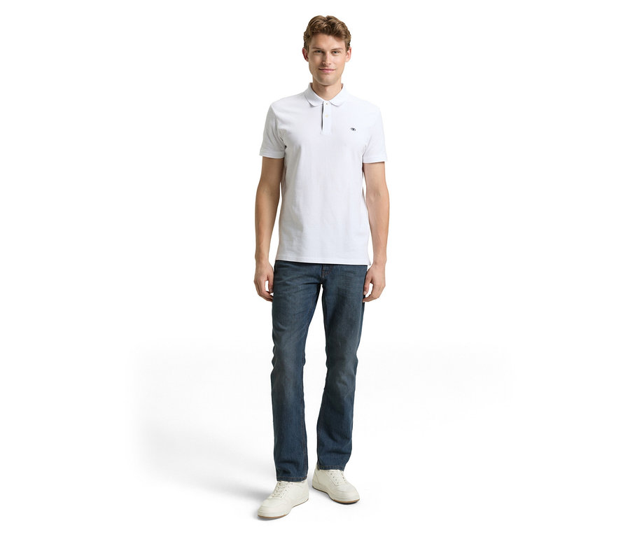 Mann in weißem Poloshirt und Tom Tailor TT MARVIN STRAIGHT Jeans mit Stretch, Mid Stone Blue Grey Denim und weißen Schuhen.
