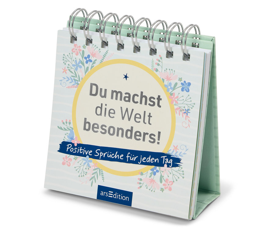 Auf einem Tisch steht ein Tischkalender mit der Aufschrift "Du machst die Welt besonders! Positive Sprüche für jeden Tag".