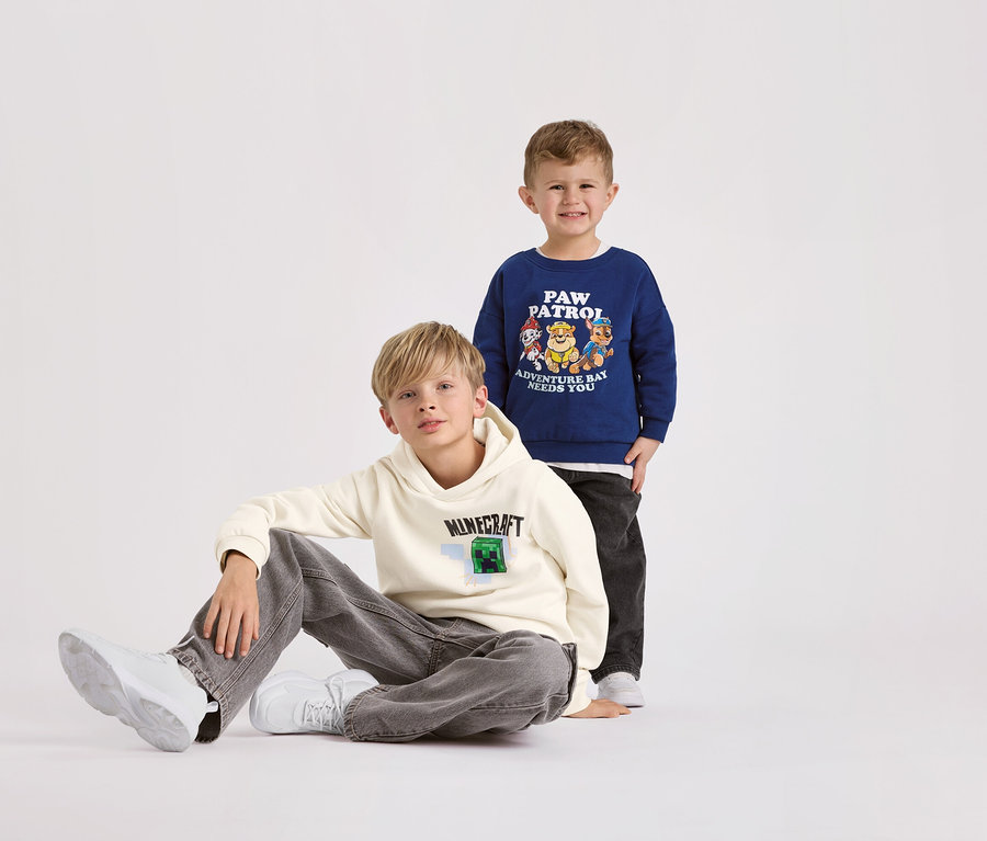 Zwei Jungen posieren vor einem weißen Hintergrund. Der Junge im Vordergrund trägt einen MINECRAFT Kinder-Hoodie mit angerauter Innenseite.