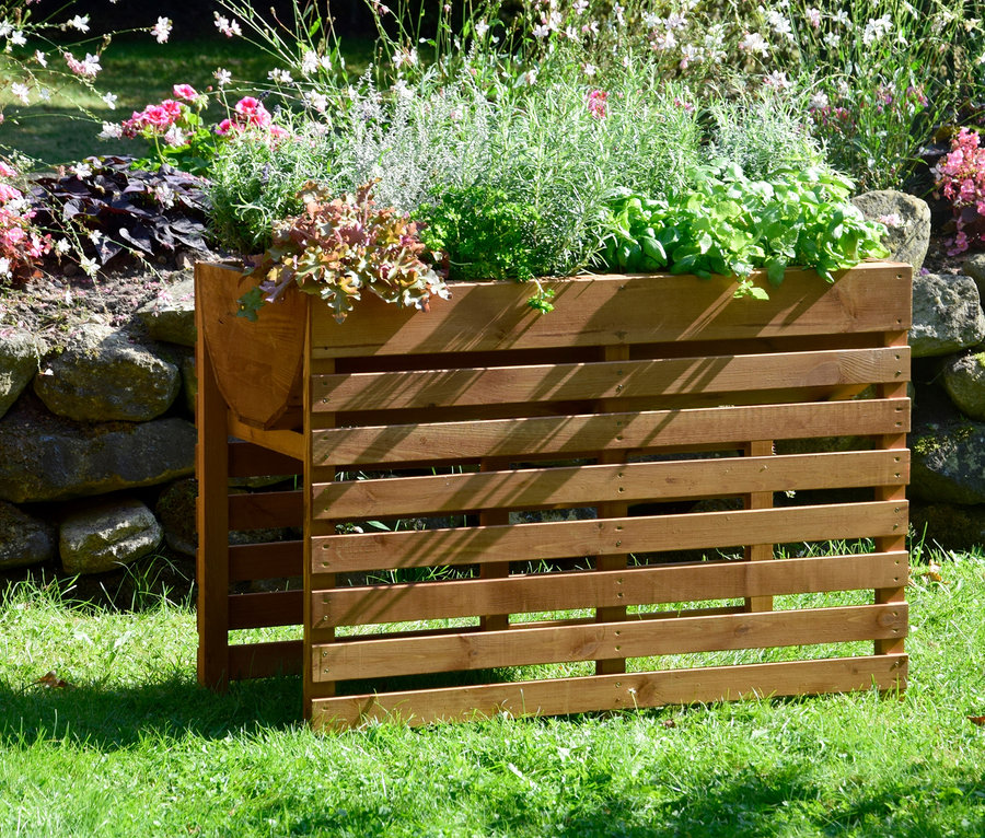 Ein braunes, doppeltes Hochbeet XL mit Pflanzen steht auf einer Wiese.