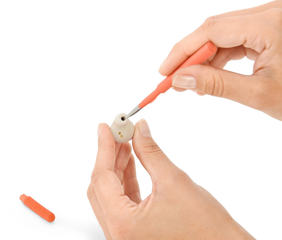 Hände reinigen einen Ohrhörer mit einem 4-in-1-Schreibtisch-Reinigungs-Set.