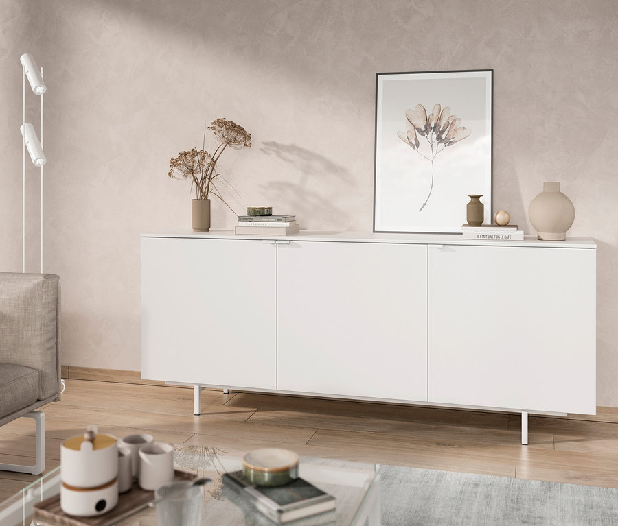 Weißes Sideboard steht im Wohnzimmer neben einem Sofa.